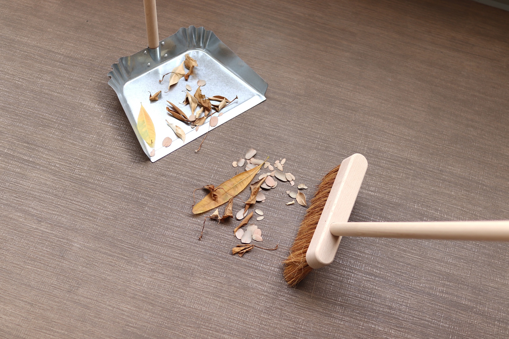 ほうきで落ち葉を掃く