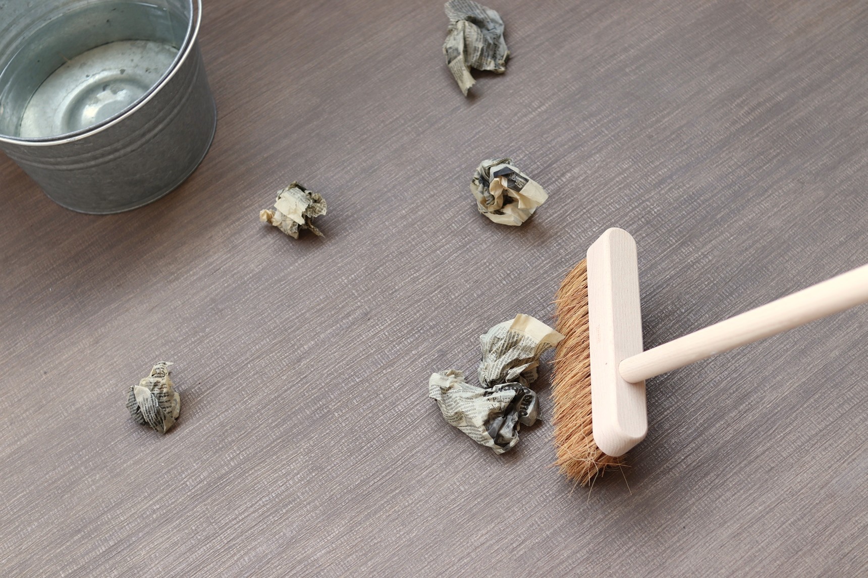 濡らした新聞紙をほうきで掃く